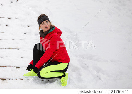 Woman tying sport shoes during winter Woman tying sport shoes during winter 121761645