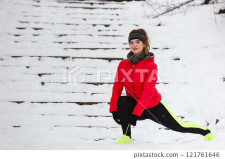 Woman exercising legs outside during winter 121761646