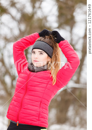 Woman wearing sportswear exercising during winter Woman wearing sportswear exercising during winter 121761649