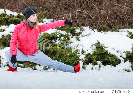 Woman wearing sportswear exercising outside during winter Woman wearing sportswear exercising outside during winter 121761690