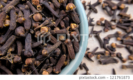 Aromatic Cloves in a Light Blue Bowl with Blurred Background, Close-Up Shot 121761873