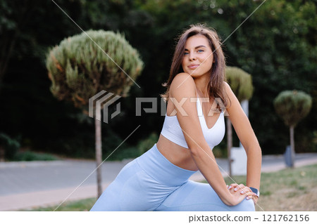 Young woman practicing yoga asana in park during summer day 121762156
