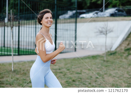 Young sportswoman running in the park enjoying her workout 121762170
