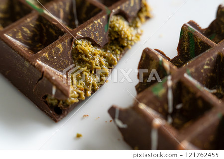 Dubai chocolate bar with pistachio paste, tahini and kataifi dough. Confectionery and sweets. Dubai chocolate bar with pistachio paste, tahini and kataifi dough. Confectionery and sweets. 121762455