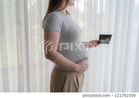 Gen Z pregnant woman holding ultrasound scan photo of a fetus. Concept of pregnancy, Maternity prenatal care Gen Z pregnant woman holding ultrasound scan photo of a fetus. Concept of pregnancy, Maternity prenatal care 121762500