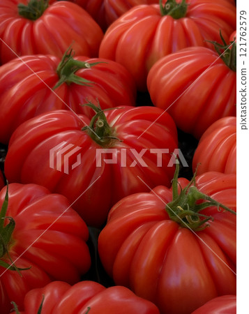 Organic tomatoes Raf Coeur De Boeuf. Concept of healthy vegetarian nutrition and vitamins. Close up Organic tomatoes Raf Coeur De Boeuf. Concept of healthy vegetarian nutrition and vitamins. Close up 121762579