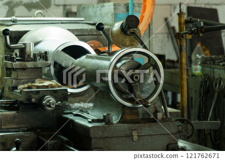 Machinery in action at a vibrant workshop creating precise metal parts 121762671