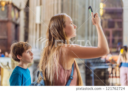 A woman and her son tourists exploring the Metropolitan Cathedral in Mexico City. Woman admiring the architecture and history of Mexico's iconic landmark. Concept of cultural heritage, religious 121762724