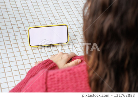 close-up image of woman in pink sitting indoors and using her smartphone. mock-up close-up image of woman in pink sitting indoors and using her smartphone. mock-up 121762888
