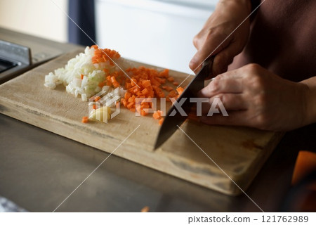 Chopping carrots and onions to make meat sauce 121762989