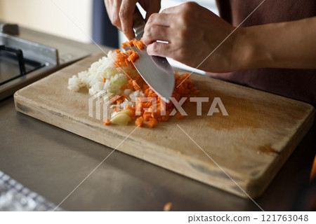 Chopping carrots and onions to make meat sauce 121763048