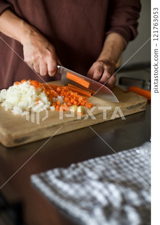 Chopping carrots and onions to make meat sauce 121763053