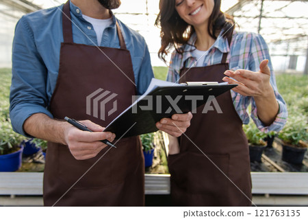 Glasshouse workers talking after quality control check and looking contented 121763135