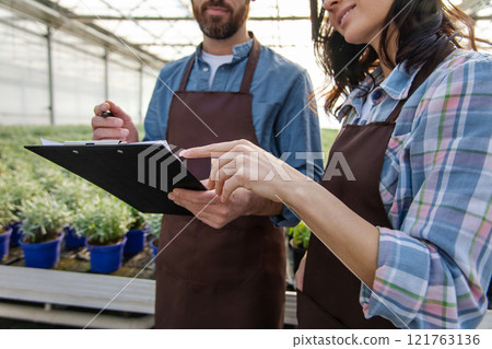 Glasshouse workers talking after quality control check and looking contented 121763136