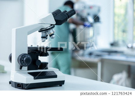 Scientist's microscope for magnifying samples and testing chemicals in lab Scientist's microscope for magnifying samples and testing chemicals in lab 121763424
