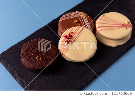 Ischler cookies coated with brown an white chocolate glaze on black Ischler cookies coated with brown an white chocolate glaze on black 121763609