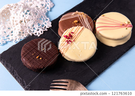 Ischler cookies coated with brown an white chocolate glaze on black Ischler cookies coated with brown an white chocolate glaze on black 121763610