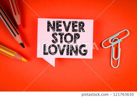 Never Stop Loving. Speech bubble with text on an orange office desk Never Stop Loving. Speech bubble with text on an orange office desk 121763630