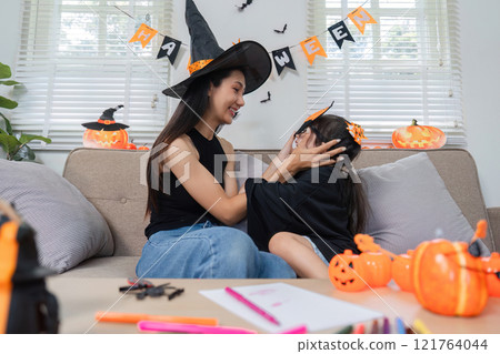 Mother and Daughter Enjoying Halloween Activities Together at Home with Costumes and Decorations Mother and Daughter Enjoying Halloween Activities Together at Home with Costumes and Decorations 121764044