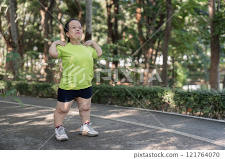 Woman Jogging in a Lush Garden Setting, Embracing Nature and Fitness in a Serene Outdoor Environment Woman Jogging in a Lush Garden Setting, Embracing Nature and Fitness in a Serene Outdoor Environment 121764070