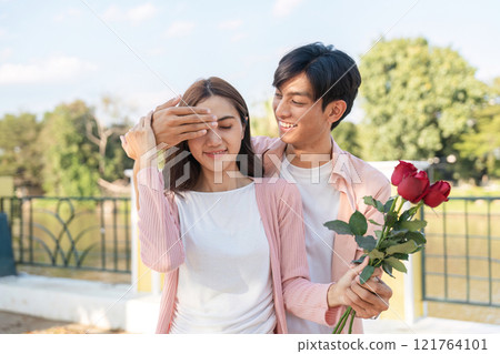 Romantic valentine's surprise couple celebrating love in a scenic park embracing the spirit of togetherness 121764101