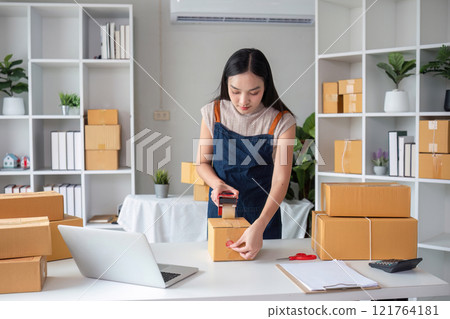 Young Female Entrepreneur Packing Orders for Online Business in Modern Home Office Young Female Entrepreneur Packing Orders for Online Business in Modern Home Office 121764181