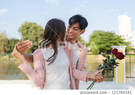 Romantic valentine surprise outdoor park couple holding roses bright day intimate moment for love celebration 121764341