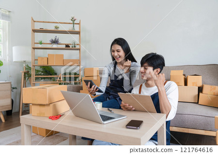 Young Couple Managing Online Order and Packing Products at Home for Their E-commerce Business 121764616