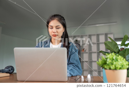 Young Woman Feeling Tired and Overwhelmed While Studying Online at Home on Her Laptop Young Woman Feeling Tired and Overwhelmed While Studying Online at Home on Her Laptop 121764654