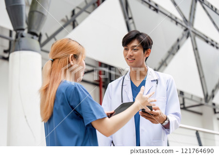 Male Doctor and Consultant Assistant Engaged in Conversation Outside Modern Building in Professional Attire Male Doctor and Consultant Assistant Engaged in Conversation Outside Modern Building in Professional Attire 121764690