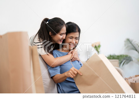 Happy Mother and Child Enjoying Quality Time with Shopping Bags After a Fun Day of Shopping Together at Home Happy Mother and Child Enjoying Quality Time with Shopping Bags After a Fun Day of Shopping Together at Home 121764811