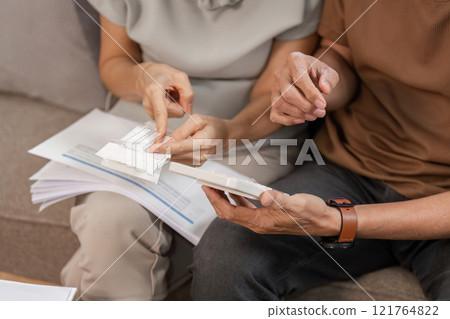 Elderly Couple Collaborating on Family Financial Planning at Home with Documents and Calculator Elderly Couple Collaborating on Family Financial Planning at Home with Documents and Calculator 121764822
