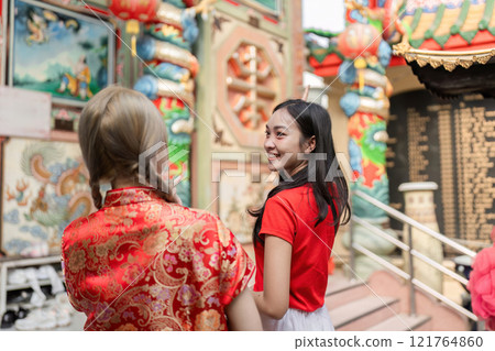 Celebrating chinese new year joyful moments with friends in a vibrant temple setting cultural celebration engaging atmosphere 121764860