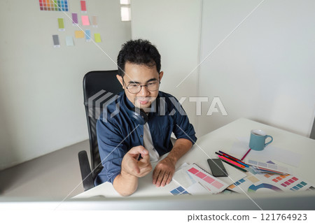 Creative Graphic Designer Working in Modern Design Studio with Color Swatches and Digital Tools for Innovative Projects Creative Graphic Designer Working in Modern Design Studio with Color Swatches and Digital Tools for Innovative Projects 121764923