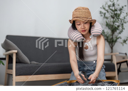 Young Woman Packing Suitcase for Travel Adventure at Home with Modern Style and Excitement for Upcoming Journey Young Woman Packing Suitcase for Travel Adventure at Home with Modern Style and Excitement for Upcoming Journey 121765114