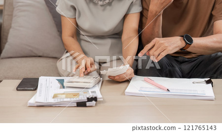 Elderly Couple Collaborating on Family Financial Planning at Home with Documents and Calculator Elderly Couple Collaborating on Family Financial Planning at Home with Documents and Calculator 121765143