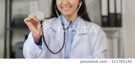 Confident Female Doctor Holding Stethoscope in Modern Medical Office Setting for Healthcare and Professional Stock Photography 121765149