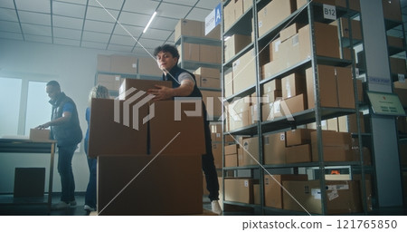 Slow motion of warehouse associate taking cardboard parcel from the shelf, loading on pallet truck Slow motion of warehouse associate taking cardboard parcel from the shelf, loading on pallet truck 121765850