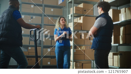 Female logistics supervisor with tablet computer talks to colleagues, gives instructions for delivery 121765907