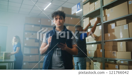 Male logistics specialist uses tablet computer and digital pencil, checks inventory 121766042