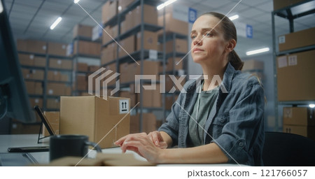Female logistics specialist scans parcel with barcode scanner, checks data using computer 121766057