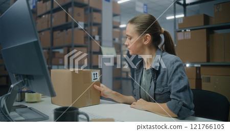Female manager scans parcel using barcode scanner, enters data on computer 121766105