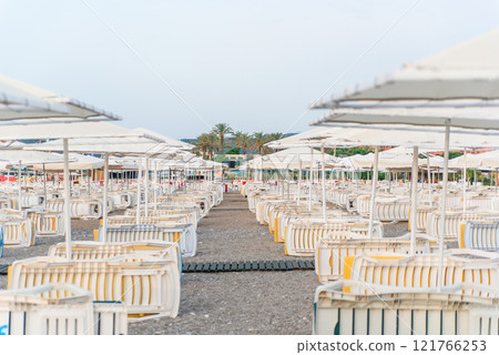 Placed in a rows lot of deck chairs on the beach at morning. 121766253