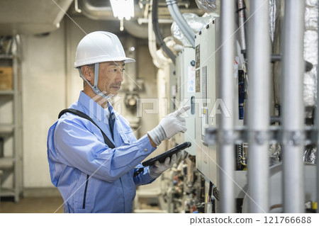 Image of a worker inspecting a building's air conditioning equipment, building maintenance staff 121766688