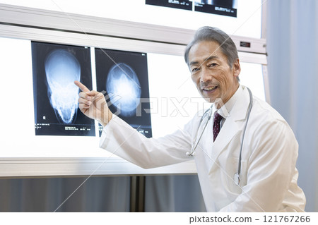 醫生一邊看頭部 X 光影像一邊解釋 121767266