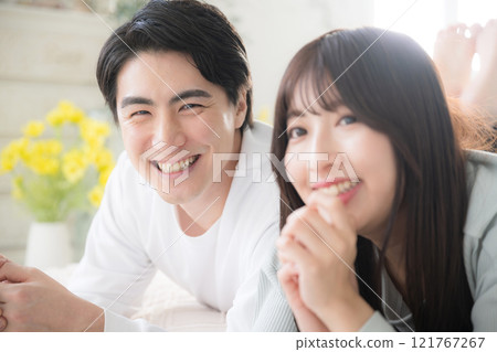 一對微笑的夫婦躺下,放鬆地趴著 一對微笑的夫婦躺下,放鬆地趴著 121767267