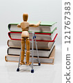Drawing doll and pile of books on a stepladder 121767383
