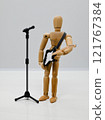 A sketch doll holding a guitar standing in front of a microphone 121767384