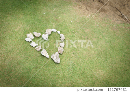 Heart-shaped stone on the grass 121767481