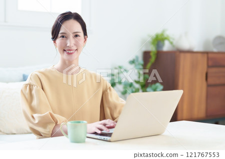 在客廳使用電腦的家庭主婦 — 在家工作圖片 在客廳使用電腦的家庭主婦 — 在家工作圖片 121767553